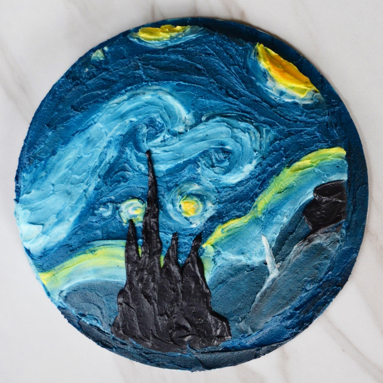 Top-down shot of a circular cake decorated to look like the Starry Night