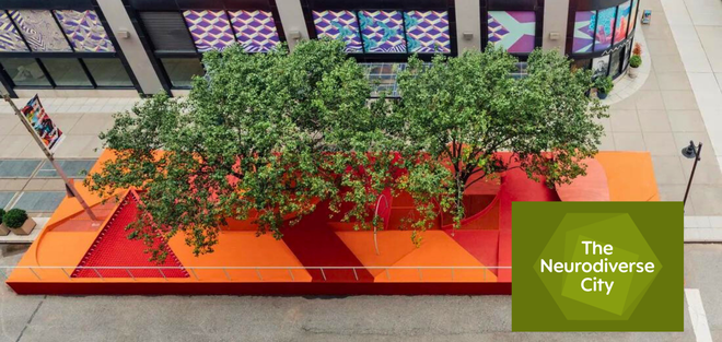 An aerial photo of a streetscape, featuring a bright red and orange raised platform covering part of the sidewalk and street. Trees poke through the platform to provide shade, and there is a metal railing on the side of the platform that borders the street. The Neurodiverse City logo (overlapping olive green polygons with the words 'The Neurodiverse City' on top in white text) is superimposed over the bottom right corner of the photo.